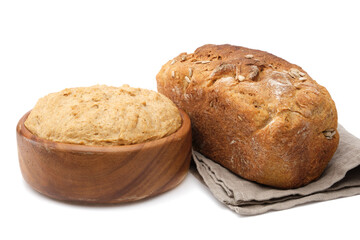 Wooden bowl of dough and freshly baked loaf on white.