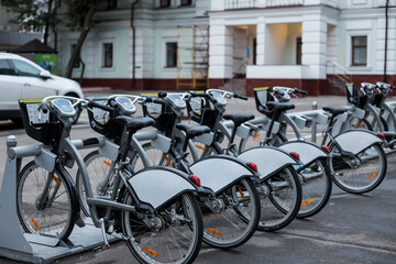 Bicycles parked in a row at the bike rental shop. Bicycles for rent. Bike rental in the city.