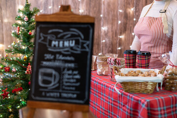 Christmas pastry shop . Woman seller, waitress selling gingerbread, marshmallows, cookies, sweets...
