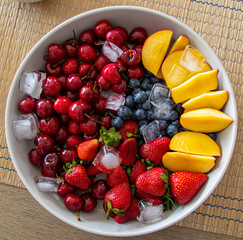 Bowl of colourful fruit strawberries black berries peach and cherries