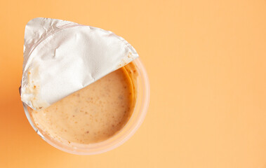 delicious nutty yoghurt open on peach background