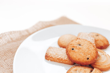 Butter cookies in a white plate on a white background.