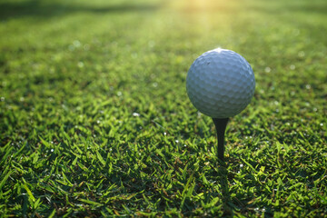 Golf ball on tee in beautiful golf course at sunset background