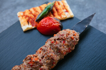 Traditional Turkish grilled shish kebab or kebap. Delicious Adana kebab on black background.