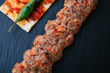 Traditional Turkish grilled shish kebab or kebap. Delicious Adana kebab on black background.