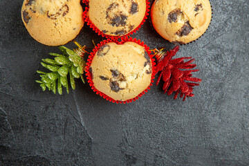Horizontal view of freshly baked delicious cupcakes and new year decoration on dark background