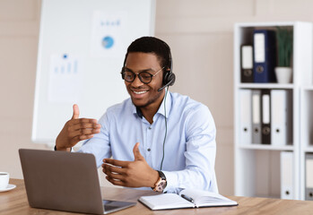 Positive african guy having business conference in office
