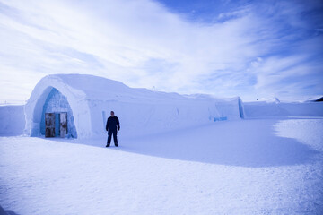 Man standing in front of a giant ice igloo
