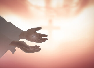 Ascension day concept: The scars In the hands of Jesus Christ over blurred holy cross on sunrise background