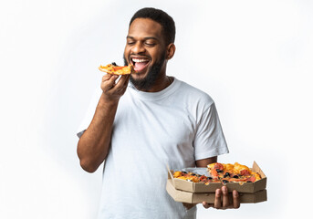 Hungry Black Guy Eating Pizza Holding Box Standing In Studio