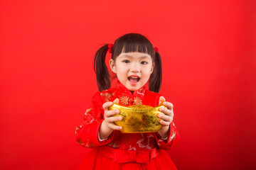 A Chinese girl celebrates the Spring Festival with gold ingots. Chinese translation of gold ingots: Gold ingot wealth