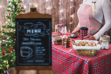 Christmas pastry shop . Woman seller, waitress selling gingerbread, marshmallows, cookies, sweets...