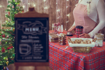 Christmas pastry shop . Woman seller, waitress selling gingerbread, marshmallows, cookies, sweets...