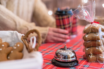 Christmas pastry shop. Woman seller, waitress, bell to warn that coffee is ready. Selling gingerbread, marshmallows, cookies, sweets and hot chocolate in a small cozy cafe.