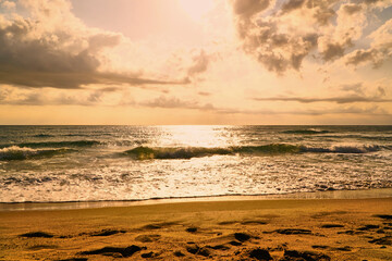 Beach sunrise and orange sea in the warm summer sun. Sandy coast and calm. High quality photo