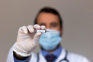 Doctor showing in hand the vaccine for coronavirus (COVID-19) for immunization against virus