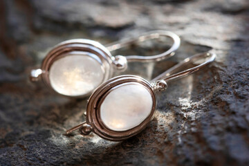 pair of sterling silver moon stone mineral earrings on natural background