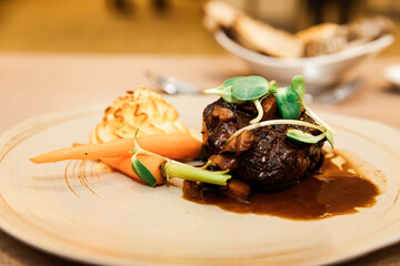 Grilled Angus beef tenderloin steak with honey glazed baby carrots, duchess potatoes and mushroom jus