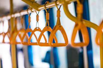Row of orange grab safety straps handles inside shuttle bus