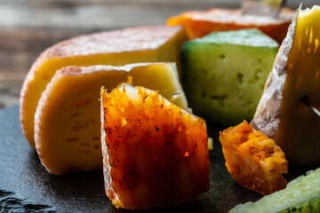 Different types of cheeses on black board. Food recipe background. Close up