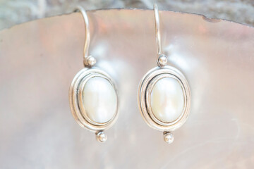 pair of sterling silver pearl earrings on natural background