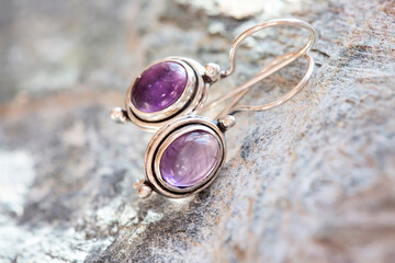 pair of sterling silver amethyst mineral earrings on natural background