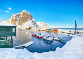 Amazing winter view on Hamnoy village with port and Festhaeltinden mountain on background.