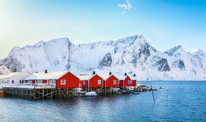 Traditional Norwegian red wooden houses (rorbuer) on the shore of  Reinefjorden near Hamnoy village