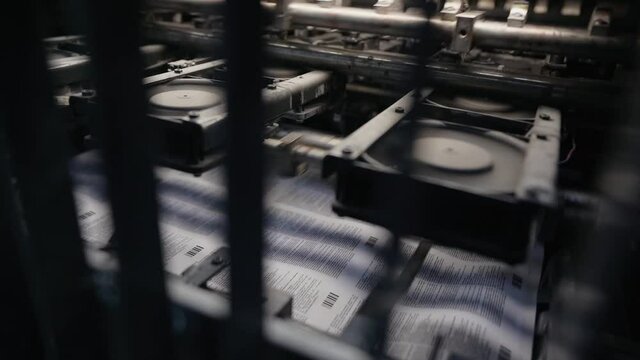 printing house machine rotates over printed newspaper. High quality FullHD footage