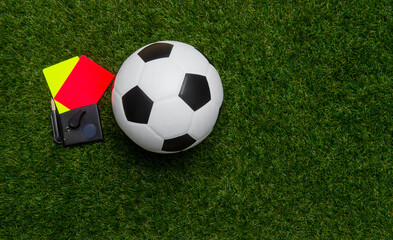 Football soccer referee equipment on green grass background. Top view, space for your text.