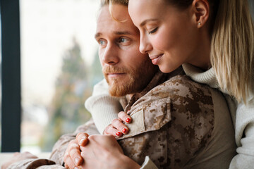 Beautiful romantic couple hugging and holding hands together at home