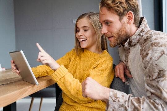 Masculine Happy Military Man Using Tablet Computer With His Smiling Daughter