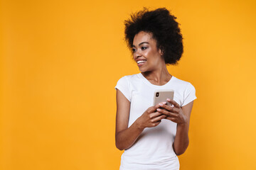 Happy young african american woman smiling and holding cellphone