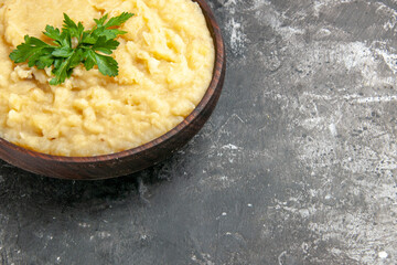 bottom half view mashed potatoes in wooden bowl on dark background with free space