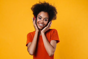 Fototapeta na wymiar Joyful african american girl in wireless headphones smiling at camera