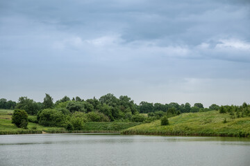 Fototapeta na wymiar Landscape with lake, forest and rain clouds.