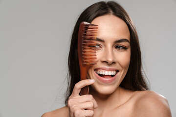 Young smiling girl with hairbrush isolated