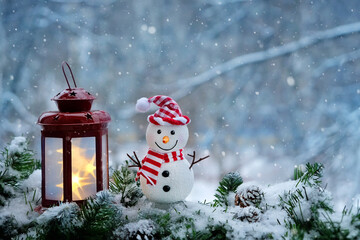 Cute snowman and Christmas lantern on winter snowy nature background. winter holiday season....