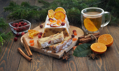 Homemade tangerine cupcake. Fir branches, spices and a cup of tea on a dark wooden table.