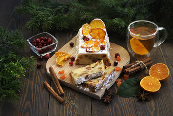 Homemade tangerine cupcake. Fir branches, spices and a cup of tea on a dark wooden table.