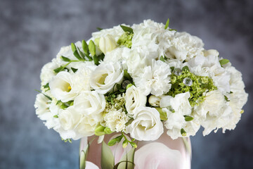 Wedding bouquet in a vase with white roses under the water drops on the mirror against grey and blue background. 