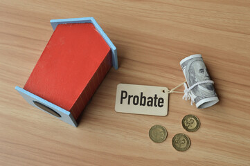 Top angle view of toy wooden house, coins. money banknote and wooden tag written with text PROBATE....