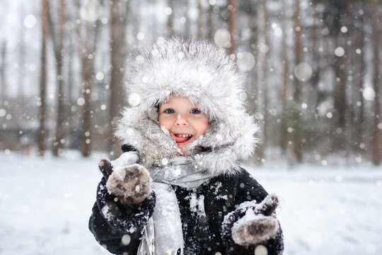 Young Boy Catching Snow On His Tongue With A Snowy Background