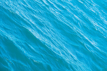 Blue sea surface background with waves. Silky texture of ocean water. Caribbean lifestyle themes