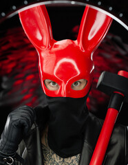a man in a red rabbit mask in a leather cloak with an axe