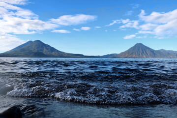 See Atitlán mit verschwommenen Vulkanen im Hintergrund
