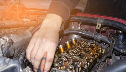 The mechanic is checking the engine.