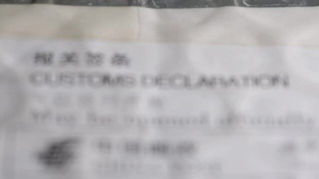 rack focus footage of postal envelope with customs declaration sign

