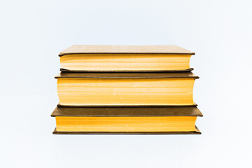 old yellowed hardback books on table background