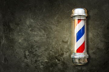 Barber pole. Barbershop pole on a textured background with copy space. - obrazy, fototapety, plakaty